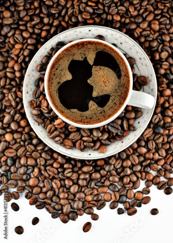 Closeup of white cup of coffe on roasted coffe beans background