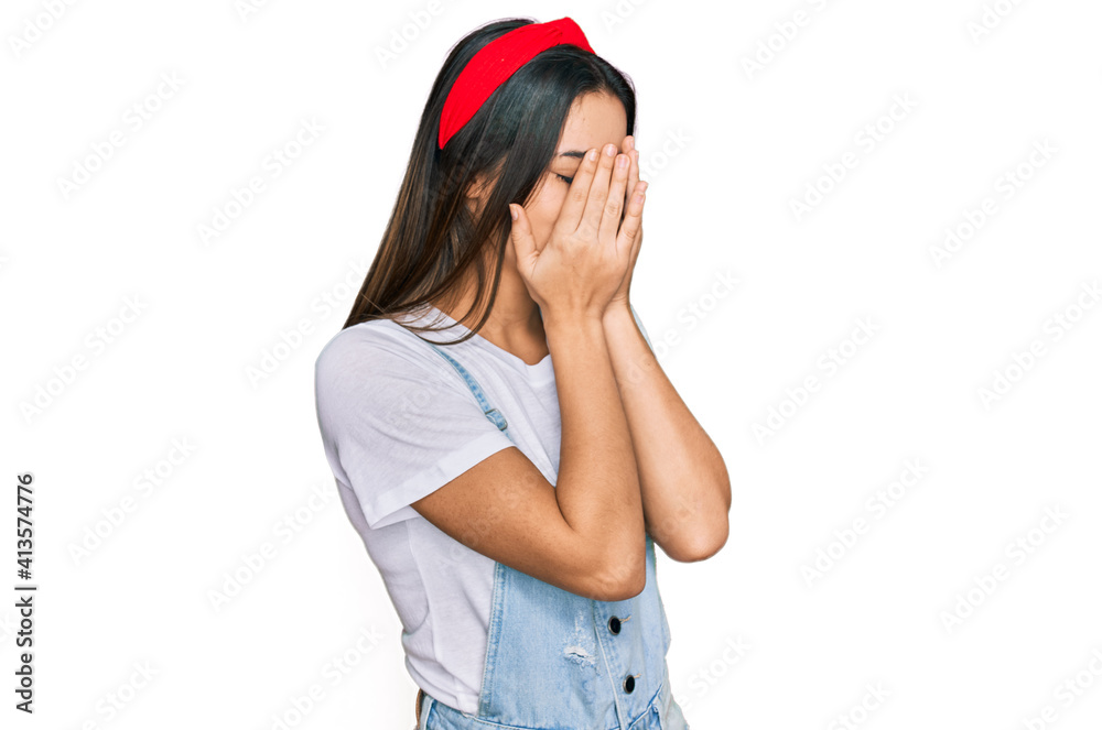 Young hispanic girl wearing casual clothes with sad expression covering face with hands while crying. depression concept. Young hispanic girl wearing casual clothes with sad expression covering face with hands while crying. depression concept.