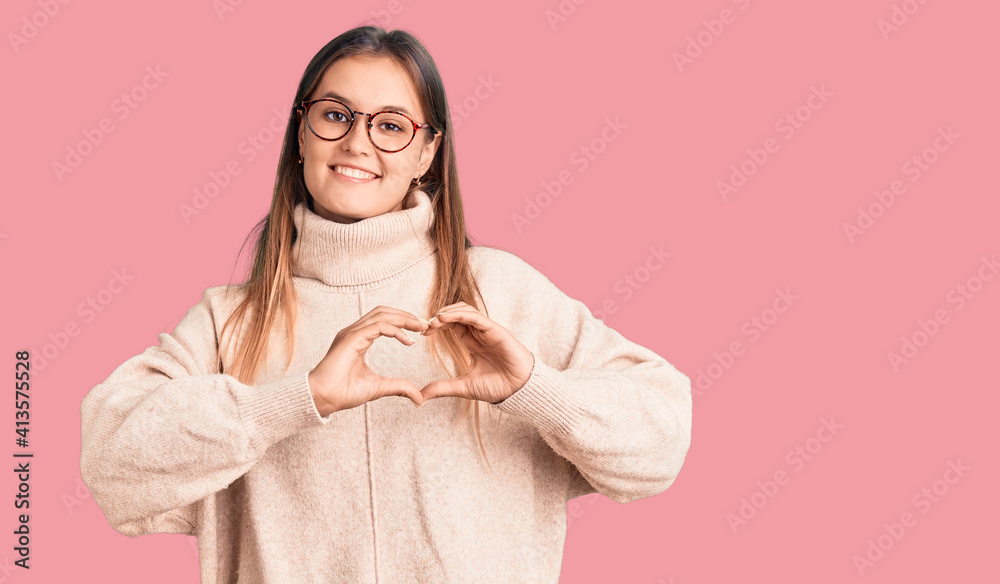 Beautiful caucasian woman wearing wool winter sweater smiling in love showing heart symbol and shape with hands. romantic concept. Beautiful caucasian woman wearing wool winter sweater smiling in love showing heart symbol and shape with hands. romantic concept.