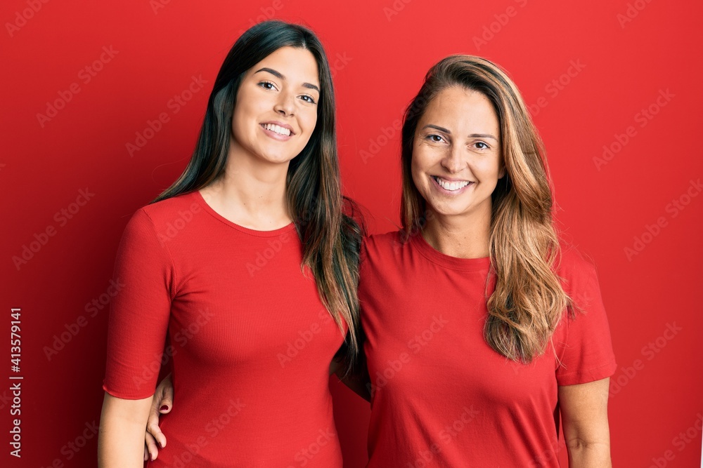 Hispanic family of mother and daughter wearing casual clothes over red background with a happy and cool smile on face. lucky person. Hispanic family of mother and daughter wearing casual clothes over red background with a happy and cool smile on face. lucky person.