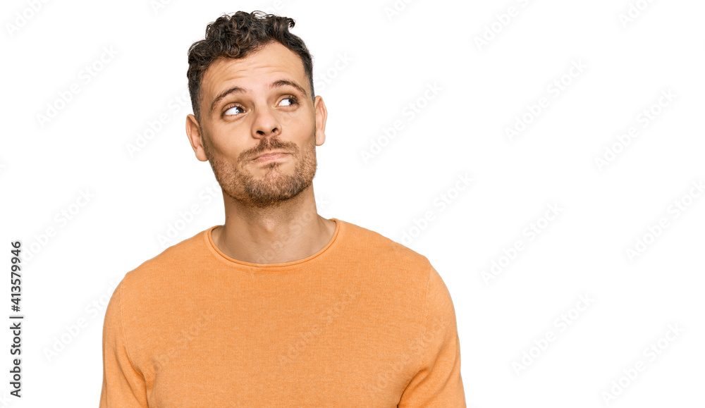 Young hispanic man wearing casual clothes smiling looking to the side and staring away thinking. Young hispanic man wearing casual clothes smiling looking to the side and staring away thinking.