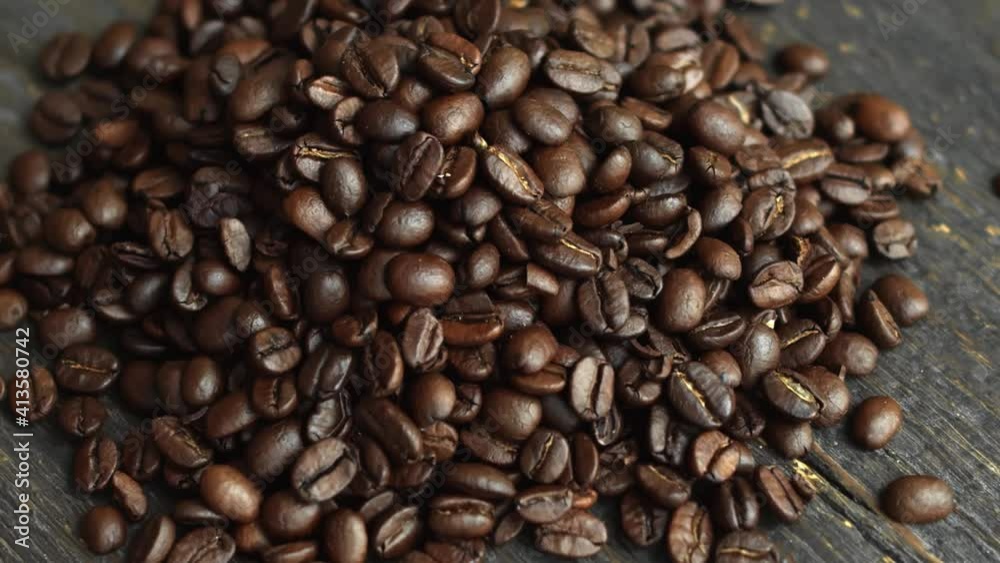 Roasted arabica coffee beans scattered on a wooden table. Fresh coffee beans. Espresso, americano, doppio, cappuccino, latte. Robusta. Selective focus. Roasted arabica coffee beans scattered on a wooden table. Fresh coffee beans. Espresso, americano, doppio, cappuccino, latte. Robusta. Selective focus.