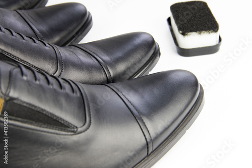 black classic beautiful shoes and sponge on a white background, close up. shoe care, shoe cleaning. © Igorzvencom