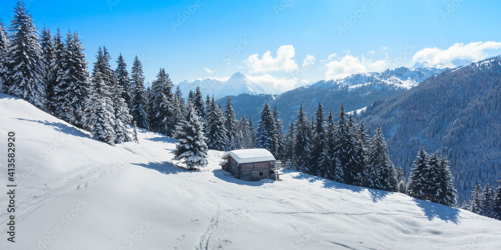 Panorama einer Winterlandschaft mit Skihütte in den Alpen