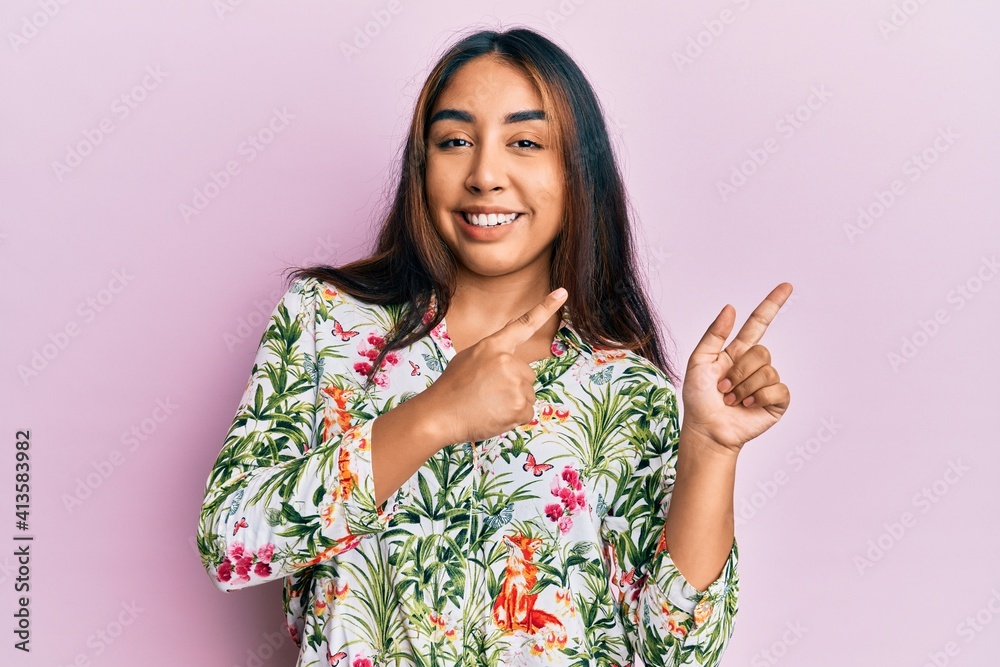 Young latin woman wearing casual clothes smiling and looking at the camera pointing with two hands and fingers to the side. Young latin woman wearing casual clothes smiling and looking at the camera pointing with two hands and fingers to the side.