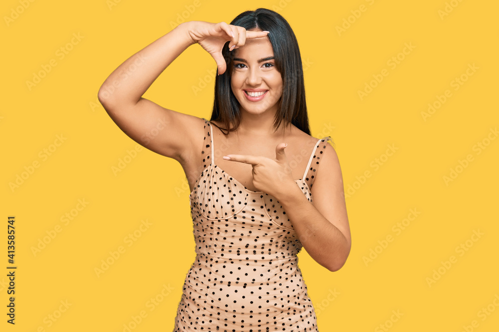 Young beautiful hispanic girl wearing sexy party dress smiling making frame with hands and fingers with happy face. creativity and photography concept.