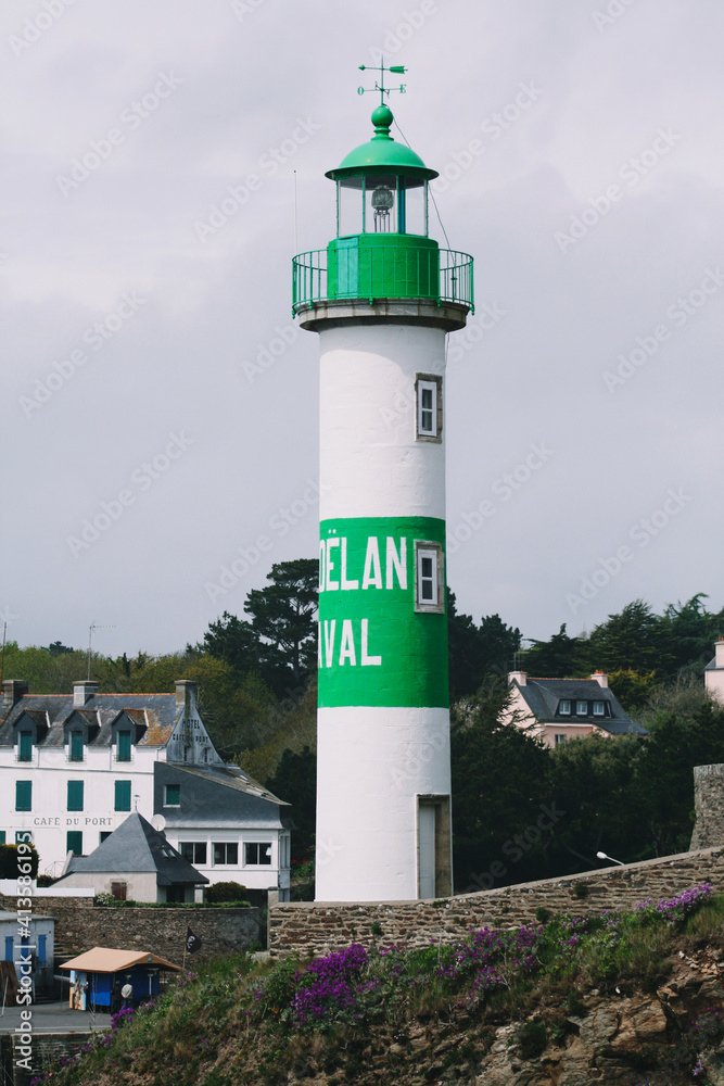 white and green lighthouse with village. Brittany, France white and green lighthouse with village. Brittany, France