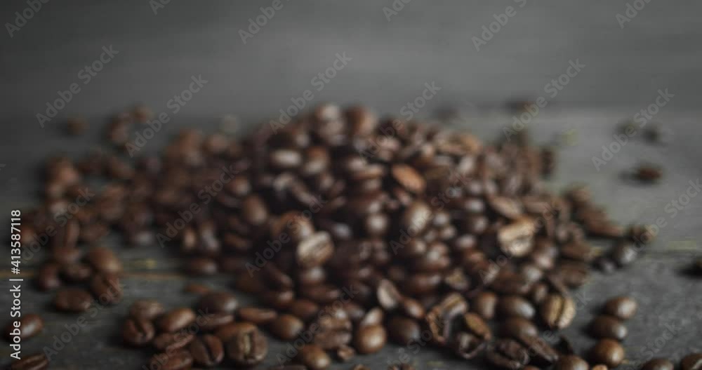 Roasted arabica coffee beans scattered on a wooden table. Fresh coffee beans. Espresso, americano, doppio, cappuccino, latte. Robusta. Selective focus.