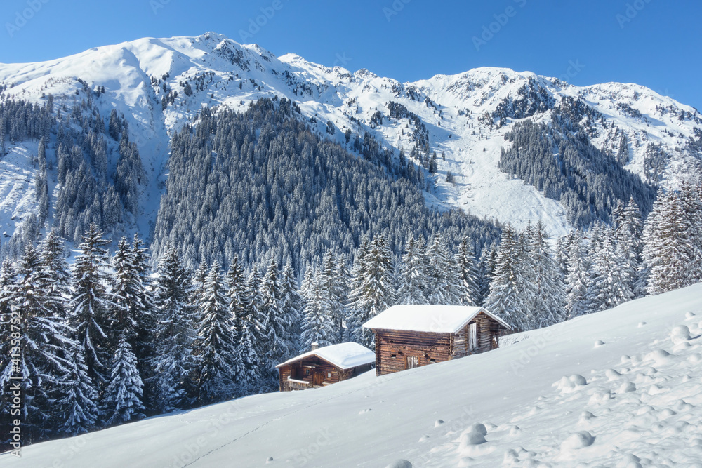 Winterlandschaft in den Bergen mit Skihütte und Almhütte