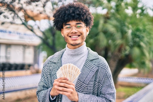 Young african american businessman smiling happy holding danmark krone banknotes at the park photo
