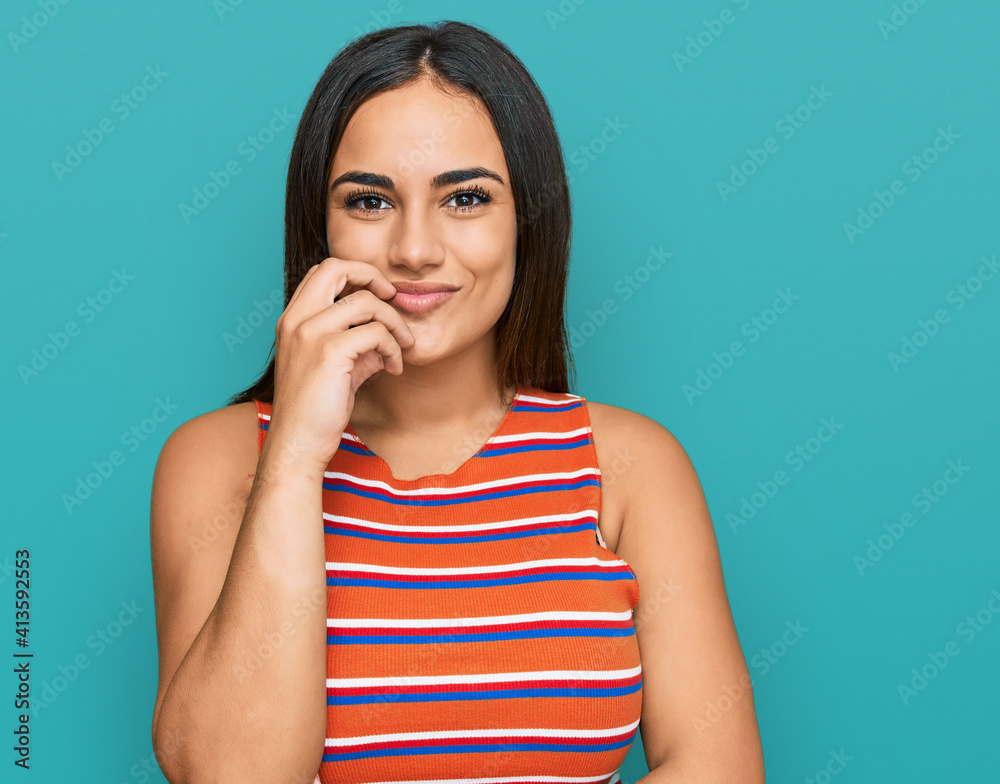 Young brunette woman wearing casual clothes looking confident at the camera with smile with crossed arms and hand raised on chin. thinking positive. Young brunette woman wearing casual clothes looking confident at the camera with smile with crossed arms and hand raised on chin. thinking positive.