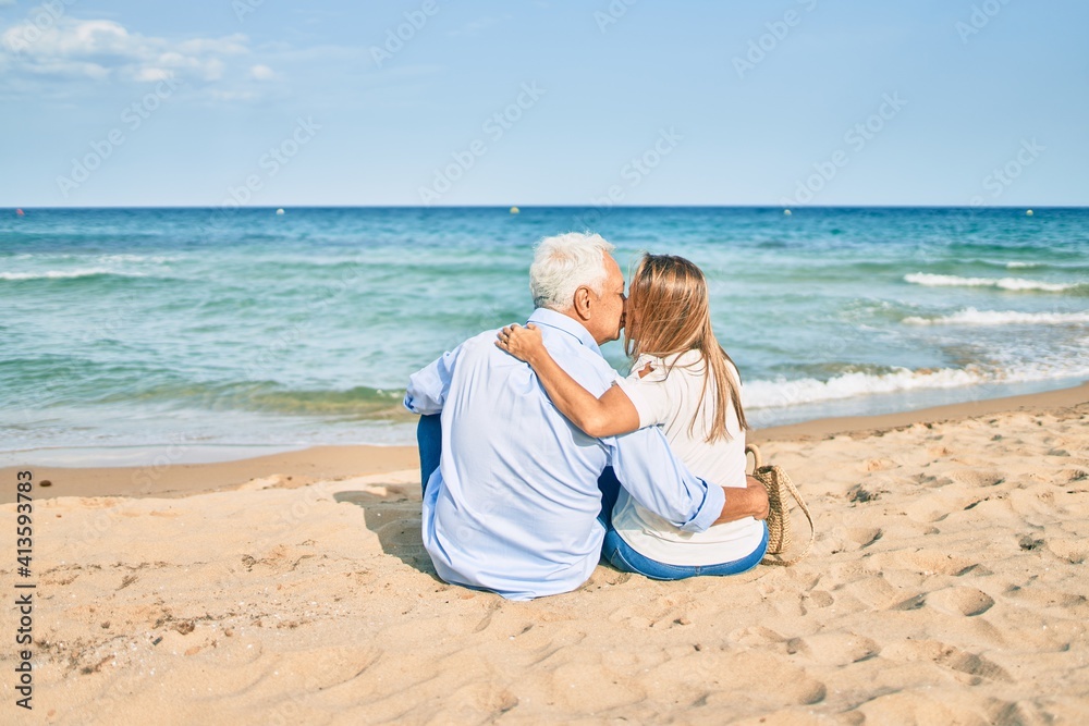 Middle age hispanic hugging sitting at the beach Middle age hispanic hugging sitting at the beach