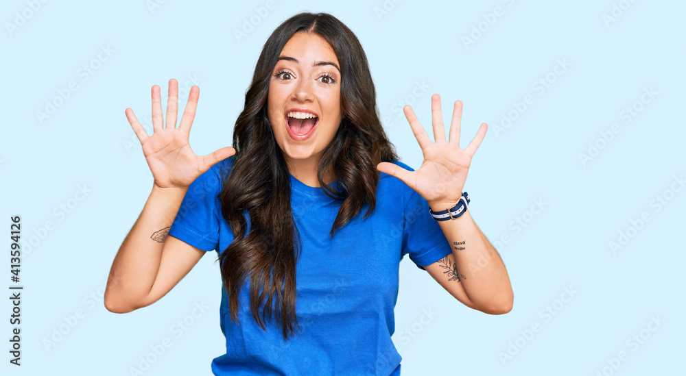 Beautiful brunette young woman wearing casual clothes showing and pointing up with fingers number ten while smiling confident and happy. Beautiful brunette young woman wearing casual clothes showing and pointing up with fingers number ten while smiling confident and happy.
