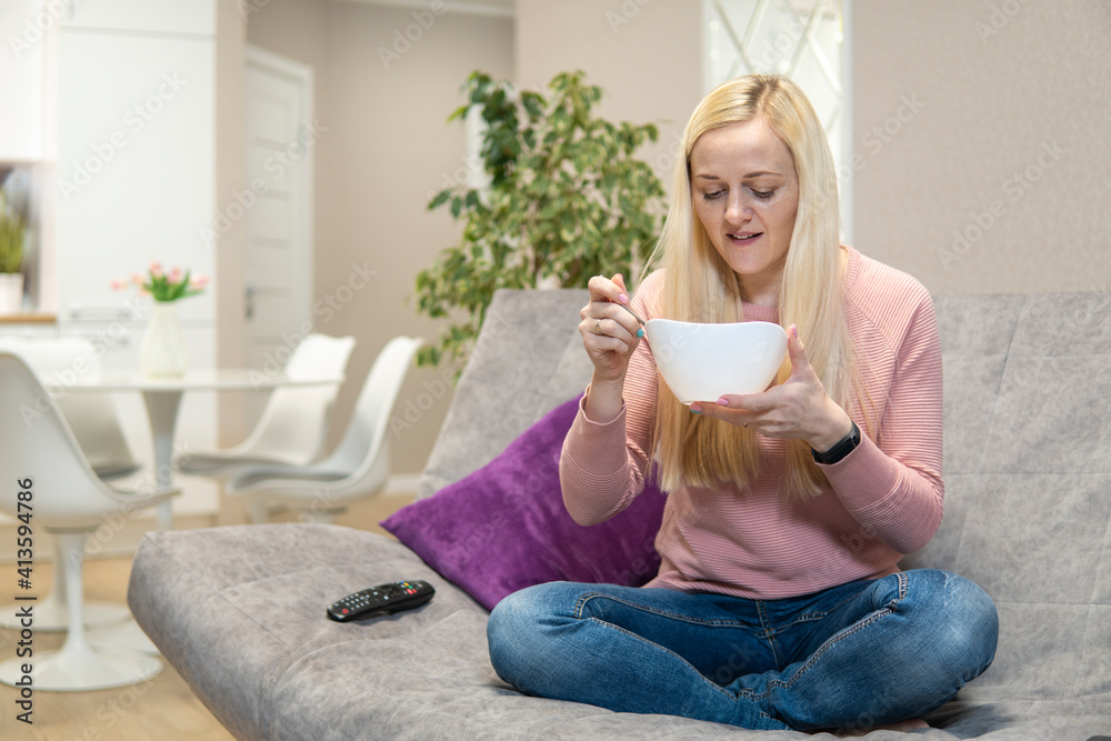 Girl with blond hair lying on the couch and chatting on the phone Girl with blond hair lying on the couch and chatting on the phone