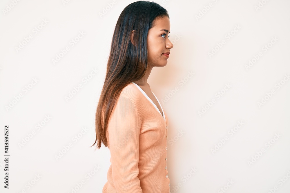 Young beautiful latin girl wearing casual clothes looking to side, relax profile pose with natural face with confident smile. Young beautiful latin girl wearing casual clothes looking to side, relax profile pose with natural face with confident smile.
