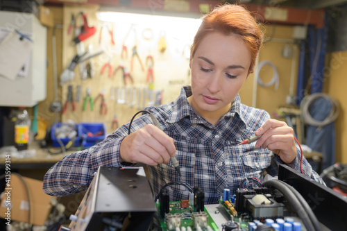 female laboratory assistant repairs pcb module for cnc robotics