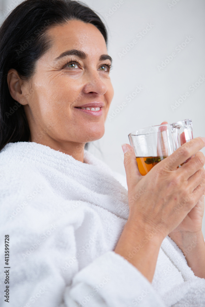 lady sitting in white bathrobe drinking coffee or tea lady sitting in white bathrobe drinking coffee or tea