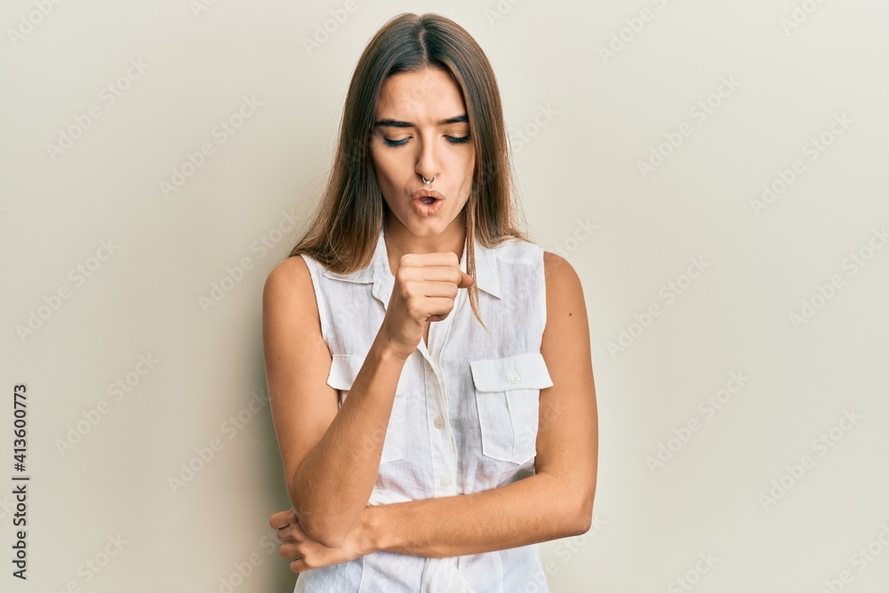 Young hispanic woman wearing casual clothes feeling unwell and coughing as symptom for cold or bronchitis. health care concept. Young hispanic woman wearing casual clothes feeling unwell and coughing as symptom for cold or bronchitis. health care concept.