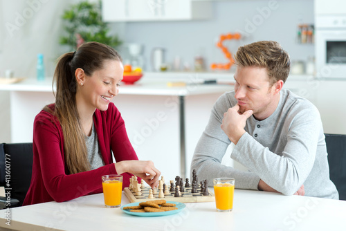 happy couple playing chess at home
