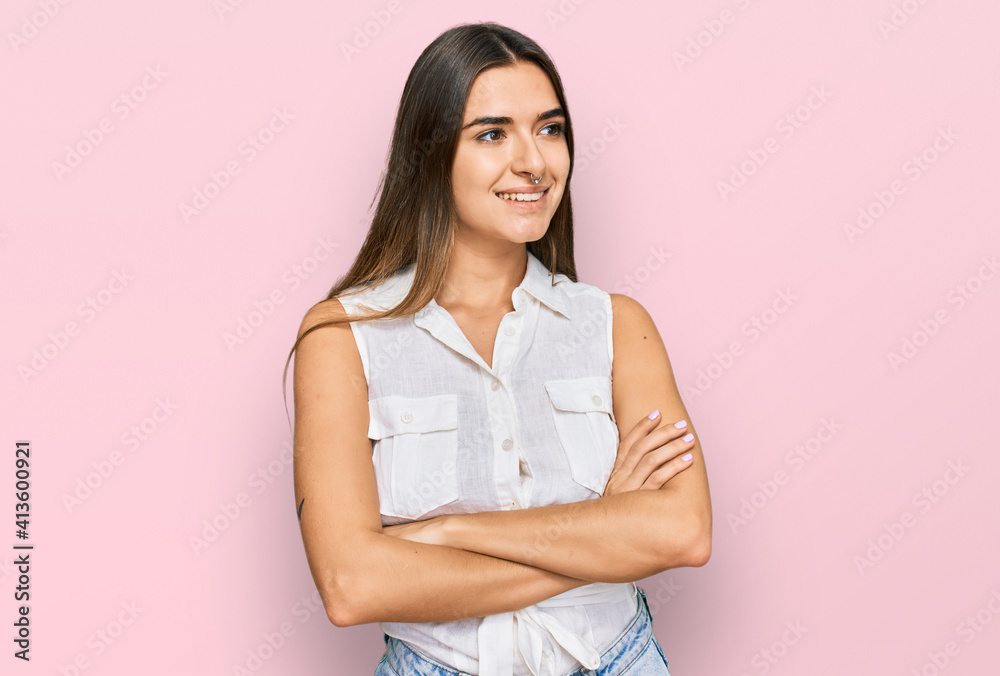 Young hispanic woman wearing casual clothes looking to the side with arms crossed convinced and confident Young hispanic woman wearing casual clothes looking to the side with arms crossed convinced and confident