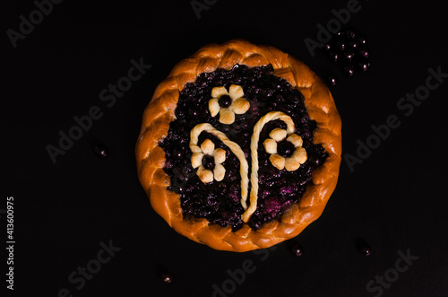 cake with black currant on a black background