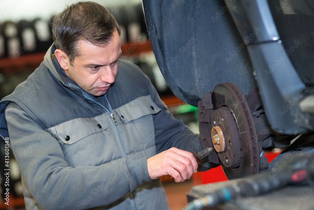 mechanic hands with tool changing tyre of car mechanic hands with tool changing tyre of car
