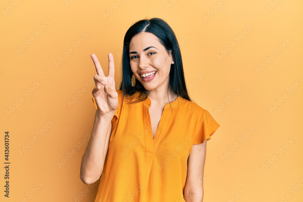 Beautiful young woman wearing casual clothes showing and pointing up with fingers number two while smiling confident and happy. Beautiful young woman wearing casual clothes showing and pointing up with fingers number two while smiling confident and happy.