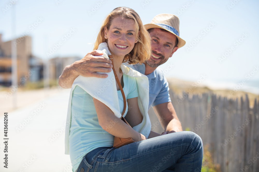 happy couple sitting on a bench by the sea
