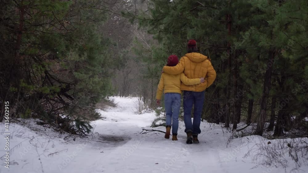 Young woman and man walking in the forest in winter. Travel and adventure concept. Young woman and man walking in the forest in winter. Travel and adventure concept.