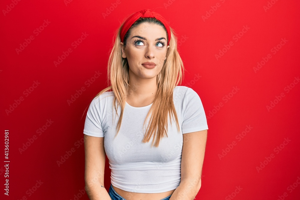 Young caucasian woman wearing casual white t shirt smiling looking to the side and staring away thinking.