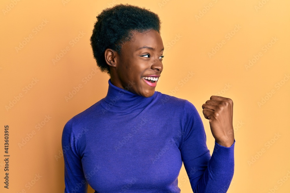 Young african american girl wearing casual clothes pointing thumb up to the side smiling happy with open mouth Young african american girl wearing casual clothes pointing thumb up to the side smiling happy with open mouth