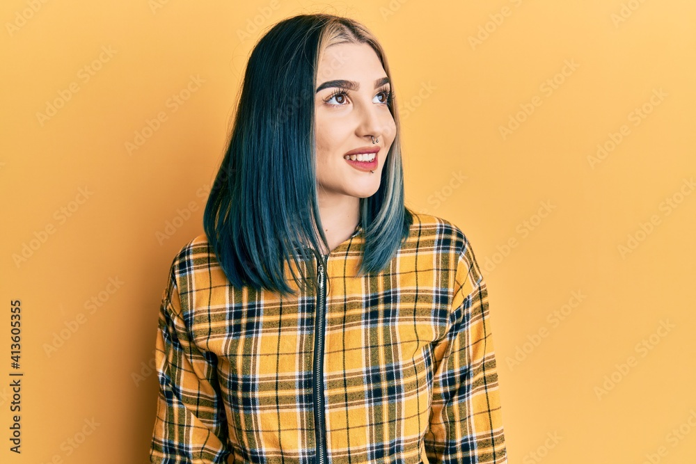 Young modern girl wearing casual yellow shirt looking to side, relax profile pose with natural face and confident smile. Young modern girl wearing casual yellow shirt looking to side, relax profile pose with natural face and confident smile.