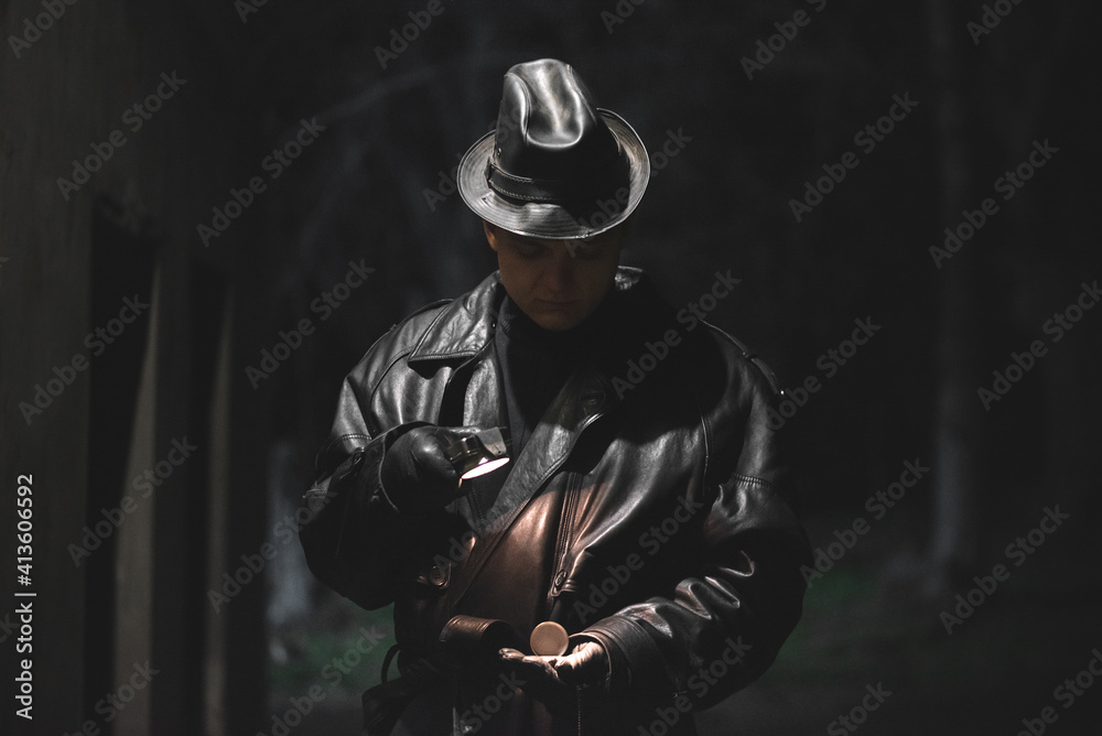 Fototapeta premium Detective agent is checking the time on his pocket watch at night.