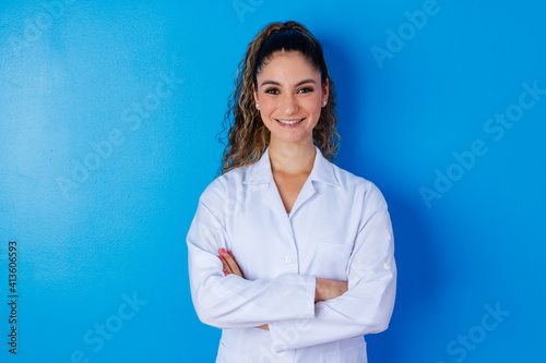 Slika na platnu Young girl in lab coat on blue background with space for text