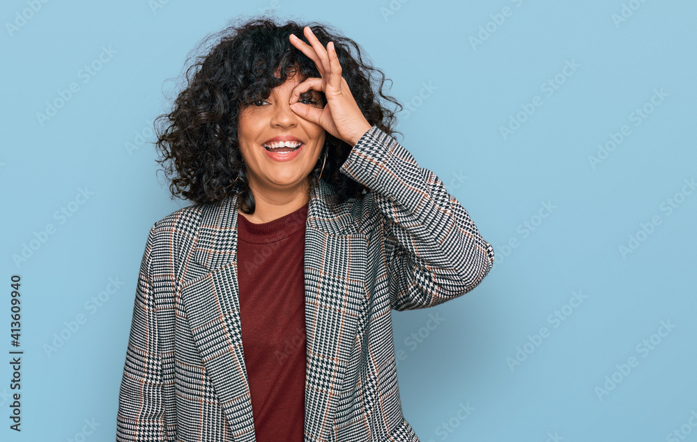 Young hispanic woman wearing business clothes doing ok gesture with hand smiling, eye looking through fingers with happy face. Young hispanic woman wearing business clothes doing ok gesture with hand smiling, eye looking through fingers with happy face.