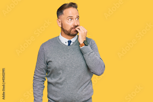 Handsome middle age man wearing business clothes looking stressed and nervous with hands on mouth biting nails. anxiety problem.
