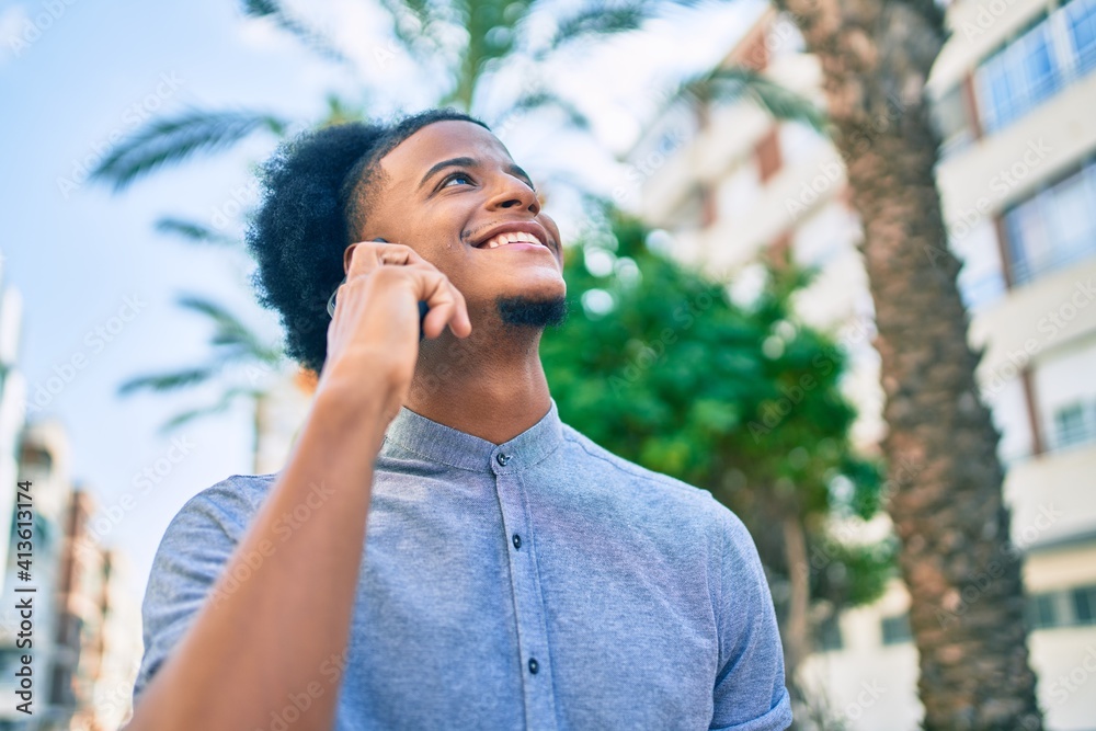 Young african american man smiling happy talking on the smartphone at the city. Young african american man smiling happy talking on the smartphone at the city.