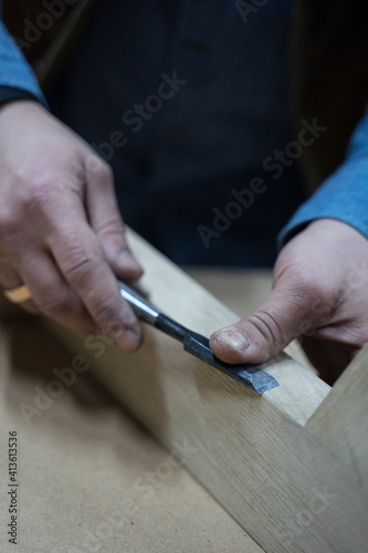 a man planes a wooden board with a special tool