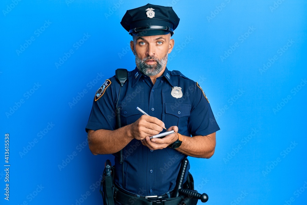 Middle age handsome man wearing police uniform writing traffic fine in shock face, looking skeptical and sarcastic, surprised with open mouth Middle age handsome man wearing police uniform writing traffic fine in shock face, looking skeptical and sarcastic, surprised with open mouth