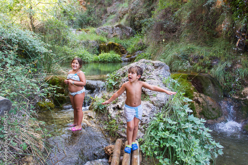 children in swimsuit, next to river, in batan de bogarra, albacete photo