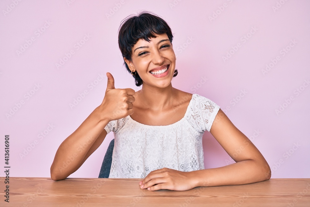 Beautiful brunettte woman wearing casual clothes over pink background smiling happy and positive, thumb up doing excellent and approval sign Beautiful brunettte woman wearing casual clothes over pink background smiling happy and positive, thumb up doing excellent and approval sign