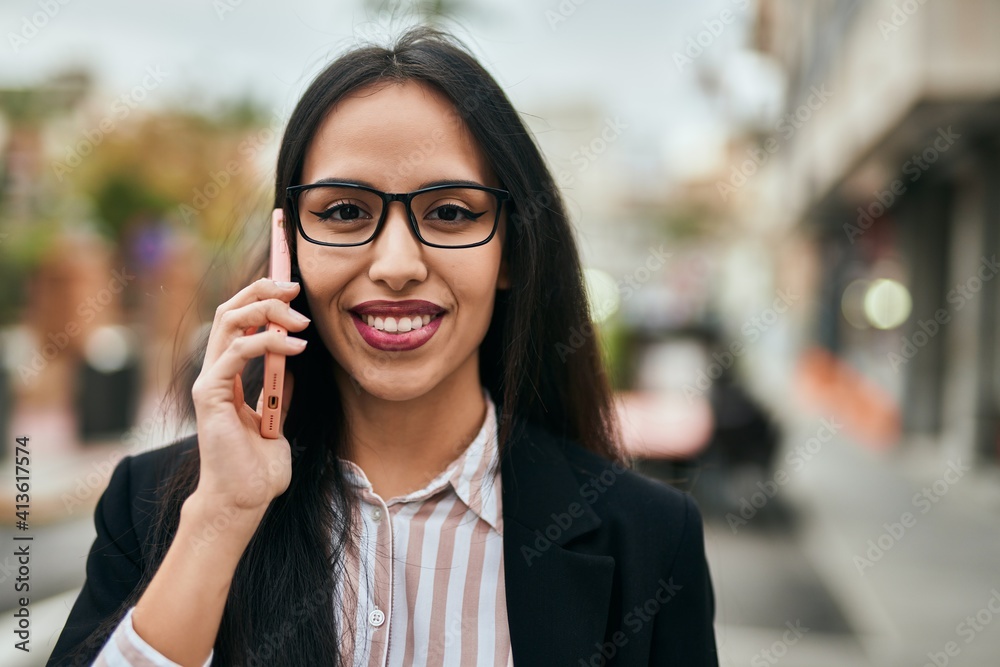 Young hispanic businesswoman smiling happy talking on the smartphone at the city. Young hispanic businesswoman smiling happy talking on the smartphone at the city.