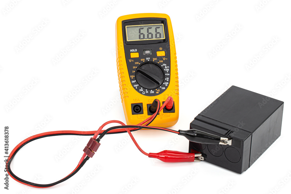 Testing an acid rechargeable battery with a measuring instrument isolated on white background