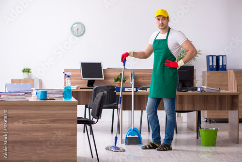 Young male contractor cleaning the office © Elnur