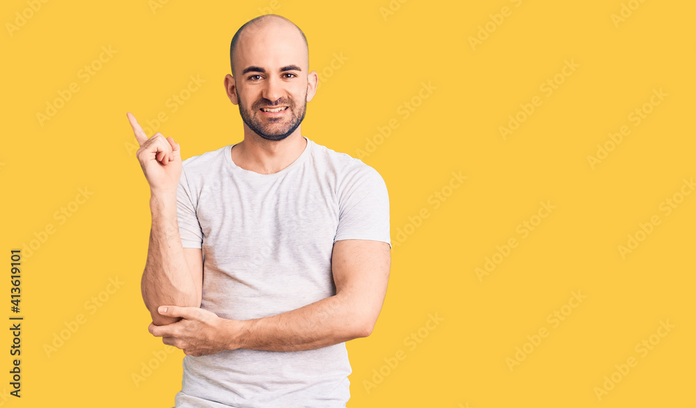 Young handsome man wearing casual t shirt with a big smile on face, pointing with hand and finger to the side looking at the camera. Young handsome man wearing casual t shirt with a big smile on face, pointing with hand and finger to the side looking at the camera.