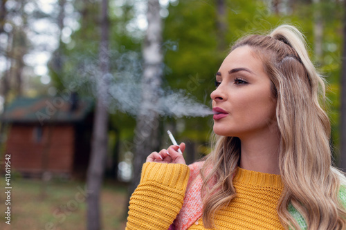 Obraz na plátně Portrait of beautiful blonde smoking outside.