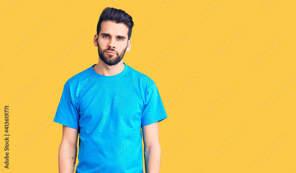 Young handsome man with beard wearing casual t-shirt relaxed with serious expression on face. simple and natural looking at the camera. Young handsome man with beard wearing casual t-shirt relaxed with serious expression on face. simple and natural looking at the camera.