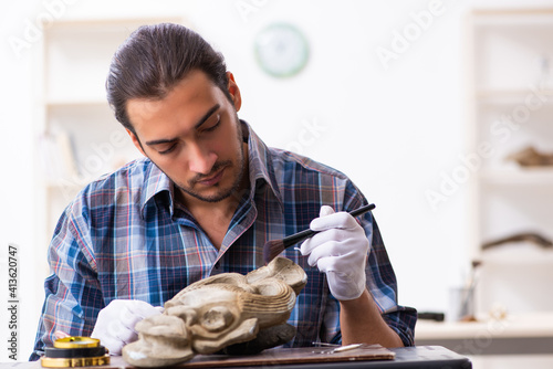 Photography Young male archaeologist studying ancient african stonemask