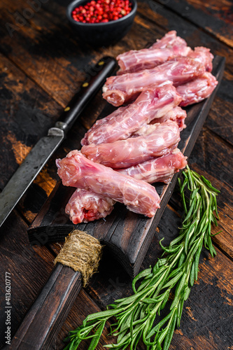 Chicken neck meat on a cutting board. Wooden background. Top view