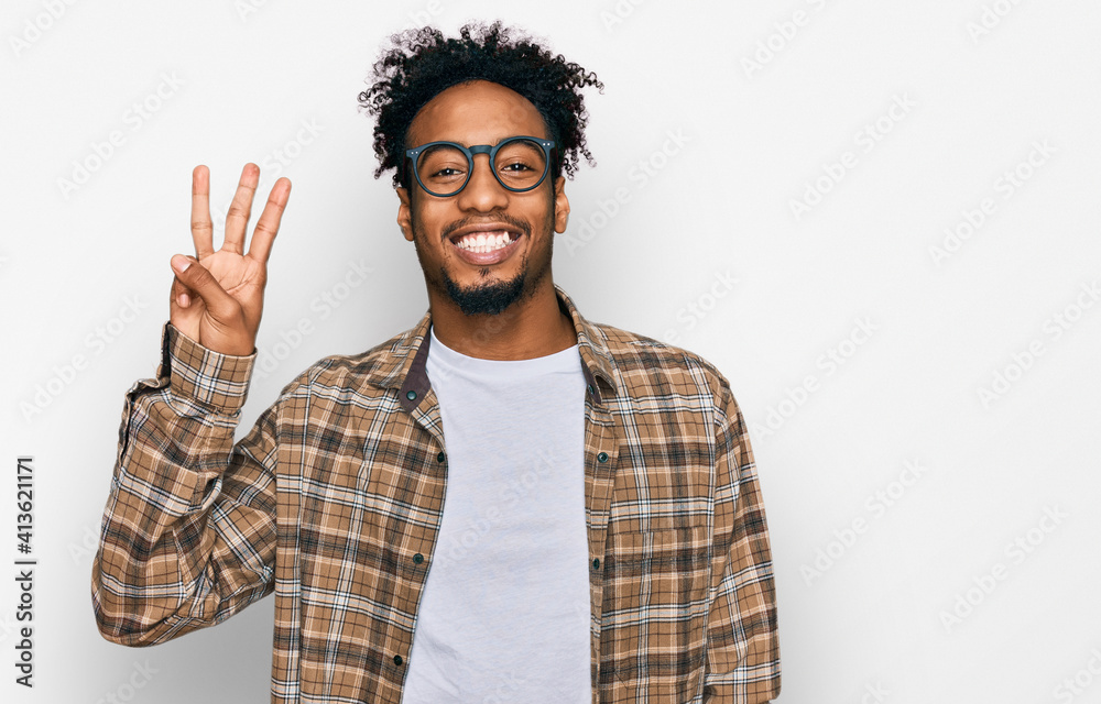 Young african american man with beard wearing casual clothes and glasses showing and pointing up with fingers number three while smiling confident and happy. Young african american man with beard wearing casual clothes and glasses showing and pointing up with fingers number three while smiling confident and happy.
